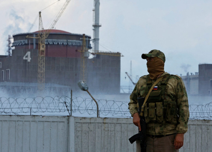 FILE PHOTO: A serviceman with a Russian flag on his uniform stands guard near the Zaporizhzhia Nuclear Power Plant in the course of Ukraine-Russia conflict outside the Russian-controlled city of Enerhodar in the Zaporizhzhia region, Ukraine August 4, 2022